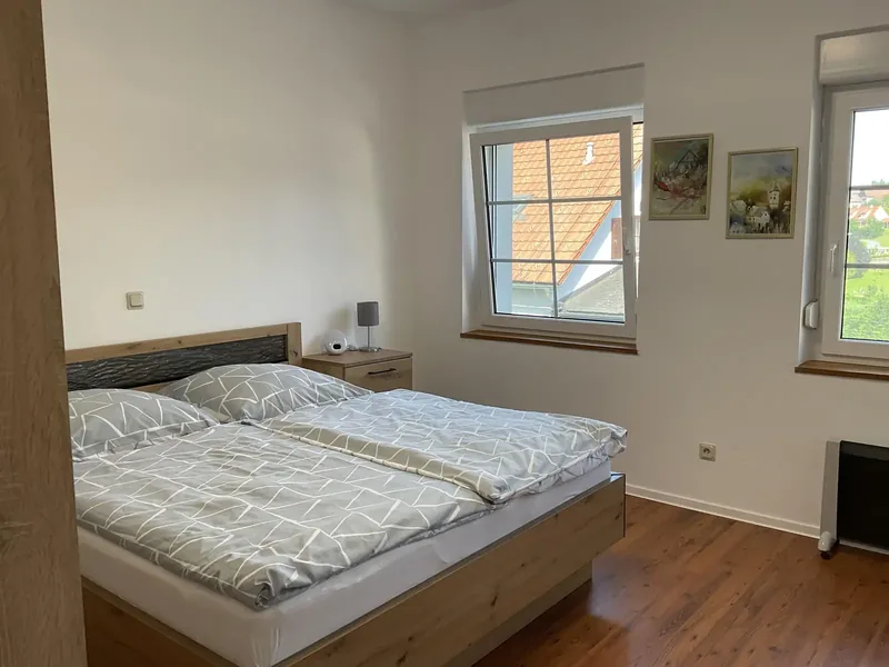 Schlafzimmer mit Doppelbett aus Eiche und zwei Fenstern